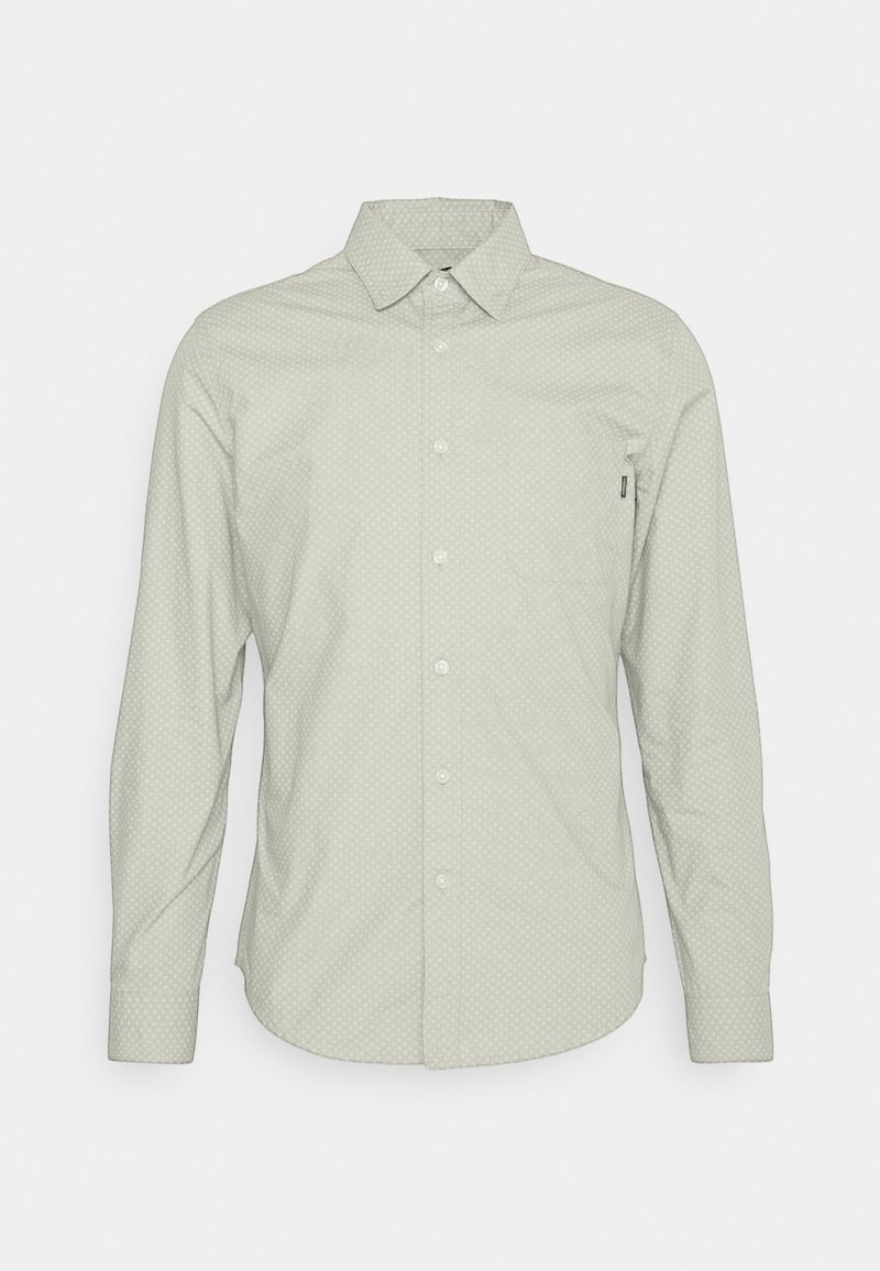 Chemise boutonnée gris clair avec un motif de pois subtil, manches longues et une poche poitrine. Le tissu semble lisse avec un col standard.