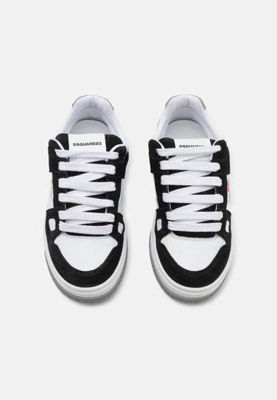 Zapatillas en blanco y negro con un upper de ante y malla, que presentan cordones blancos, una suela de goma gruesa y la marca DSQUARED2 en la lengüeta.