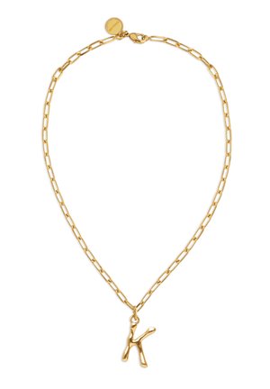 Collar de cadena de oro con eslabones rectangulares y un colgante irregular en forma de letra K, cuenta con un cierre de langosta y una pequeña etiqueta redonda.