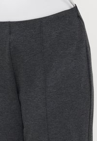 Gray, textured pants featuring a smooth waistband and a tailored fit, with a subtle heathered finish. No visible pockets or embellishments.