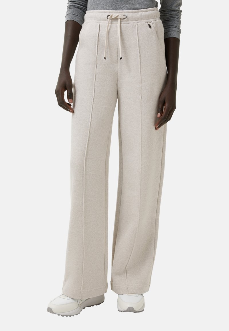 Beige weit geschnittene Sweatpants aus weichem Material, mit einem Kordelzugbund, seitlichen Nähdetails und einem lässigen Schnitt im Knöchelbereich.