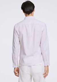 Camicetta a maniche lunghe a righe sottili di colore crema, con strisce blu e rosa, polsini con bottone e colletto a risvolto.