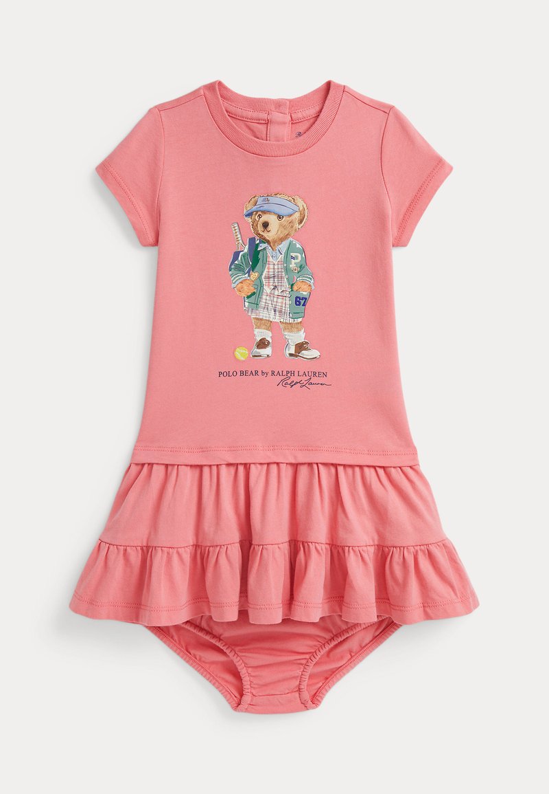 Koraļu rozā mazuļa kleita ar īsām piedurknēm, frillētu svārku un lāča grafiku sporta apģērbā priekšā. Izgatavota no mīksta kokvilnas.