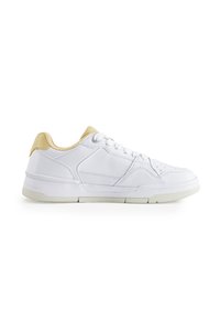 Witte sneaker met een soepel leren bovenwerk, beige accenten op de hiel en een gestructureerde zool. Beschikt over een klassieke vetersluiting en gestikte details.
