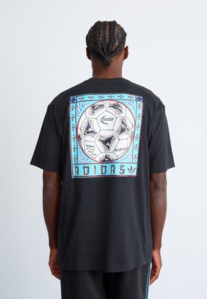 Sort bomulds T-shirt med et stort, multicolor grafisk tryk af en fodbold på ryggen, indrammet med dekorative accenter og tekst.