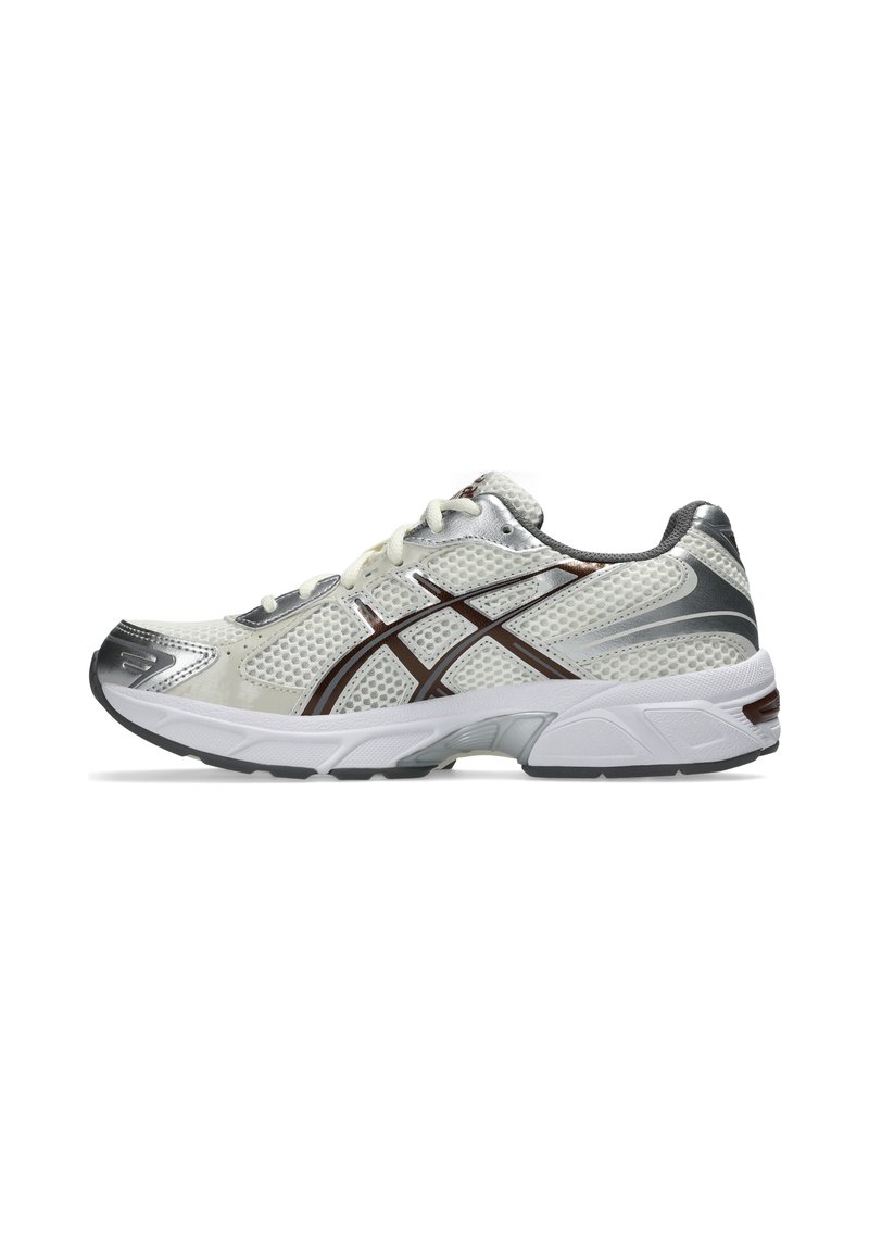 Buty sportowe w białej siateczce z srebrnymi i brązowymi akcentami. Posiadają amortyzowaną podeszwę oraz fakturowane wstawki zapewniające oddychalność.