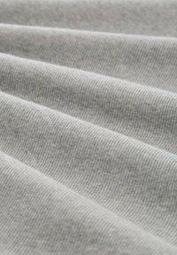 Tissu ribbé gris clair avec une surface texturée, montrant de multiples plis et lignes. Texture douce avec des variations subtiles d'ombre.
