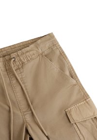 Beige cargo kalhoty s elastickým pasem, detaily na šňůrku a několika kapsami. Vyrobeny z měkké, hladké látky s mírným leskem.