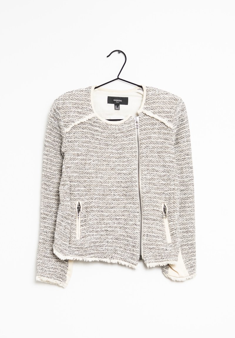 Blazer gris texturé avec accents crème, doté d'une fermeture éclair à l'avant et de deux poches zippées. Ourlet et poignets effilochés pour un détail supplémentaire.