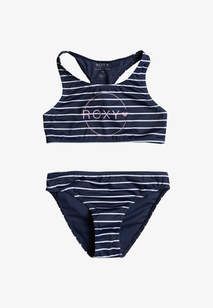 Conjunto de bikini a rayas azul marino que incluye un top corto con tirantes cruzados y el logo rosa "ROXY", acompañado de braguitas de tiro bajo a juego.