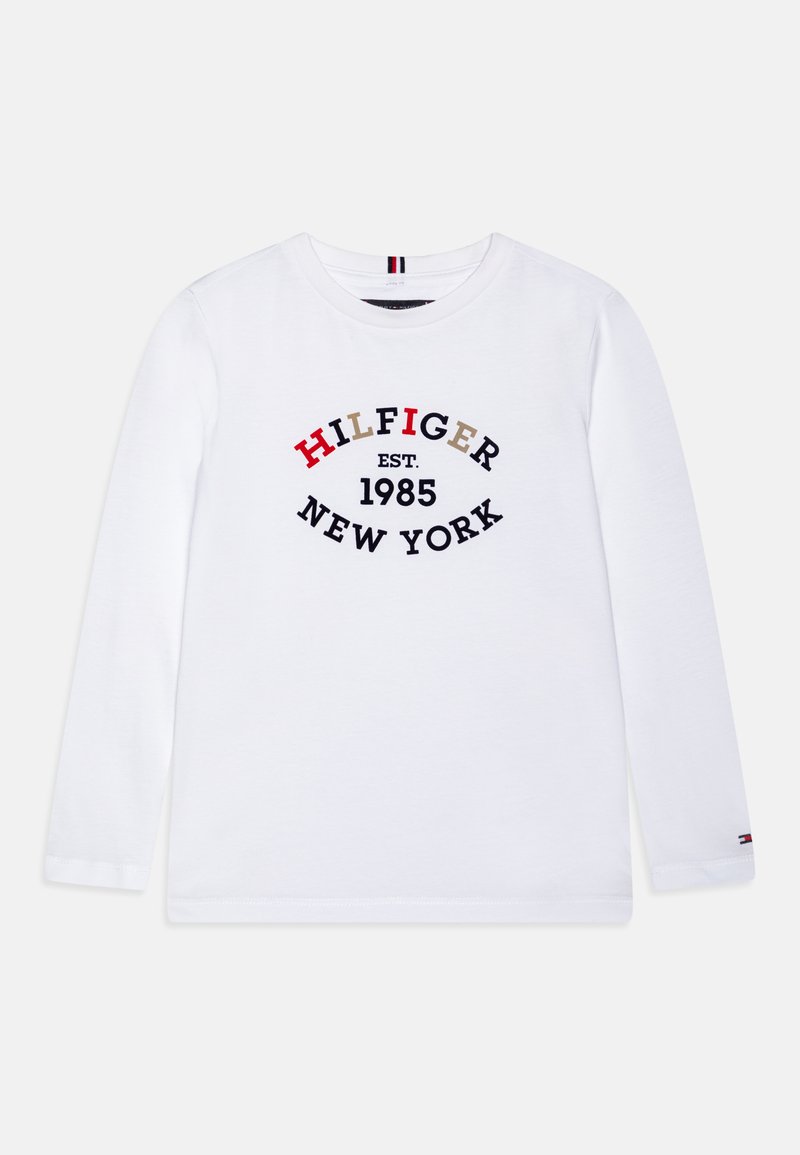 Hvit langermet t-skjorte laget av bomull, med et sirkulært grafisk motiv som har "HILFIGER," "EST 1985," og "NEW YORK" i rød, svart og beige.