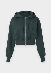 Skraćena tamnozelena dukserica s kapuljačom od mekog materijala, s prednjim patent zatvaračem, velikim prednjim džepovima i bijelim Nike logotipom na prsima.