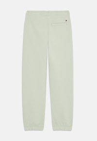 Ljusgröna sweatsbyxor med elastisk midja och ankle cuffs. Har en bakficka och en liten logotypetikett nära midjan. Mjuk, slät textur.