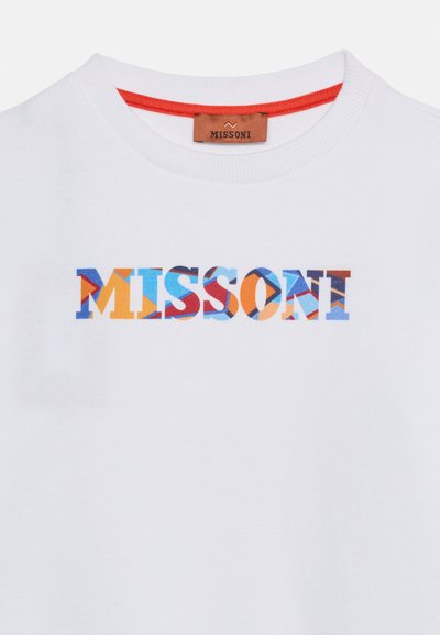 T-shirt blanc à col rond avec un logo "MISSONI" coloré et à motif centré sur la poitrine, et une bordure rouge à l'intérieur du col.
