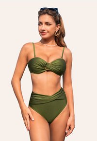 Conjunto de bikini verde con un diseño anudado y un acento de anillo dorado en la parte superior. La parte inferior de talle alto presenta una textura envuelta. Acabado suave.