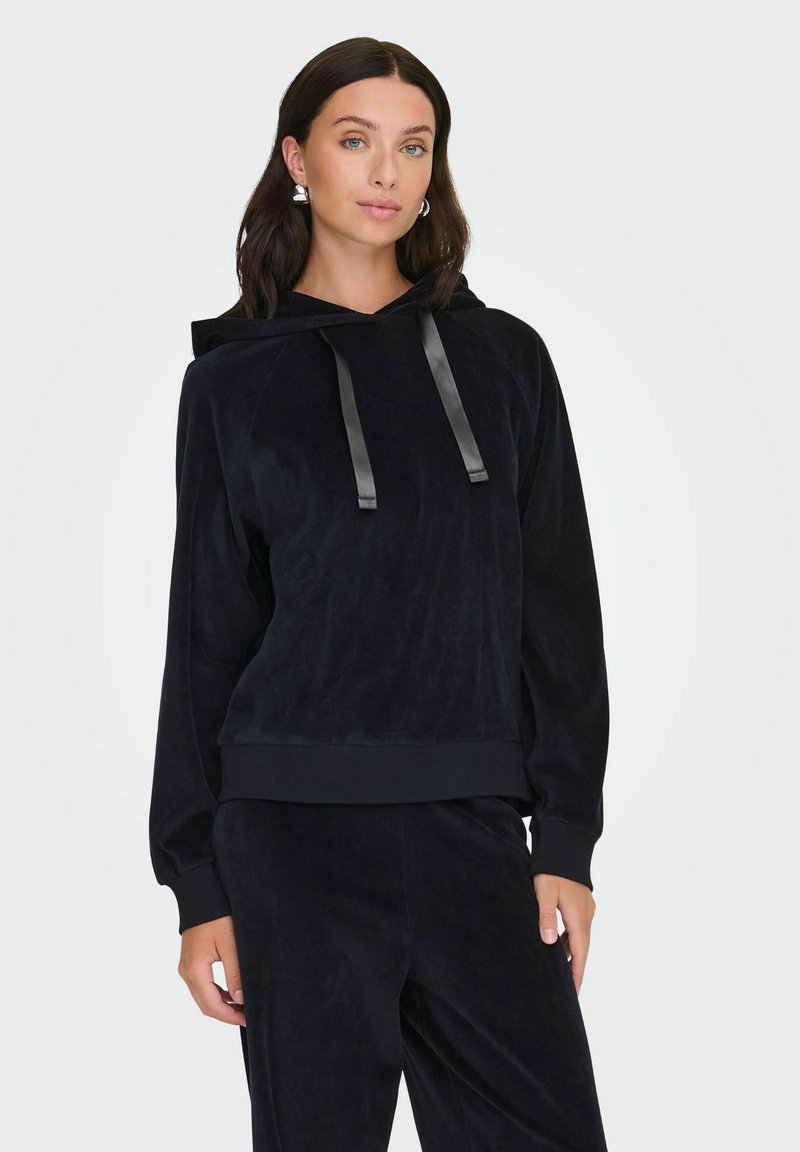 Sweat à capuche en velours noir avec une coupe décontractée, doté d'une capuche ajustable par cordon et de poignets côtelés. Texture lisse et léger éclat subtil. Associé à un bas assorti.