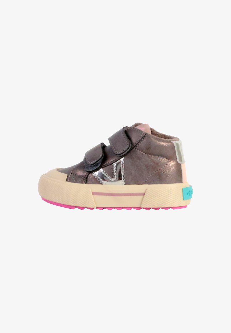 Baskets montantes métalliques gris foncé avec deux bandes Velcro noires, bout en crème, semelle rose et détail découpé transparent.
