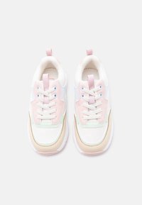 Paire de baskets blanches avec des accents pastel rose, vert, bleu et beige, lacets blancs et languettes, vues de dessus sur un fond blanc.