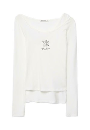 Maglia bianca a maniche lunghe a strati con scollo rotondo, presenta una piccola illustrazione nera di Cupido e la scritta "Favorito di Cupido" sul petto.
