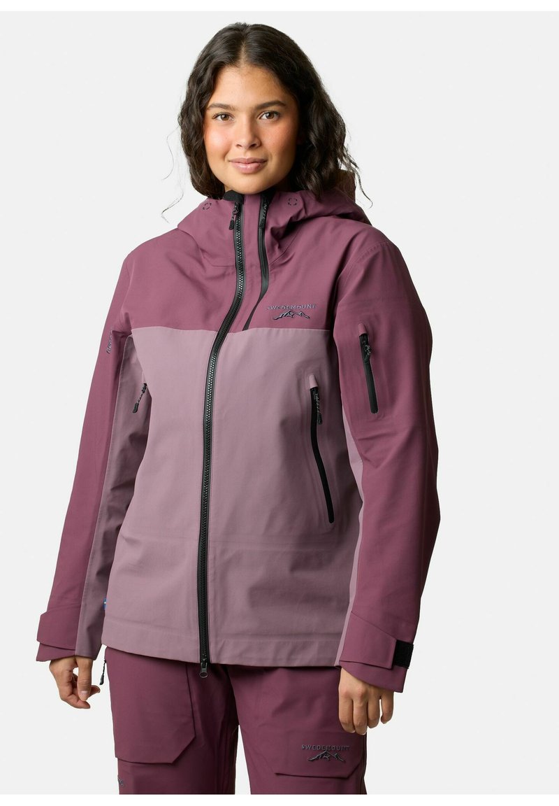 Veste imperméable dans deux nuances de violet avec une capuche, plusieurs poches zippées et des poignets ajustables pour un ajustement sécurisé.