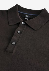 Dunkelbraunes Poloshirt mit strukturiertem Stoff, drei grauen Knöpfen an der Knopfleiste und einem Kragen mit subtilen blauen Akzenten.