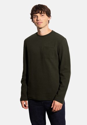 Camicia a maniche lunghe in cotone verde scuro con scollatura rotonda e taschino sul petto, caratterizzata da un tessuto testurizzato e una vestibilità comoda.