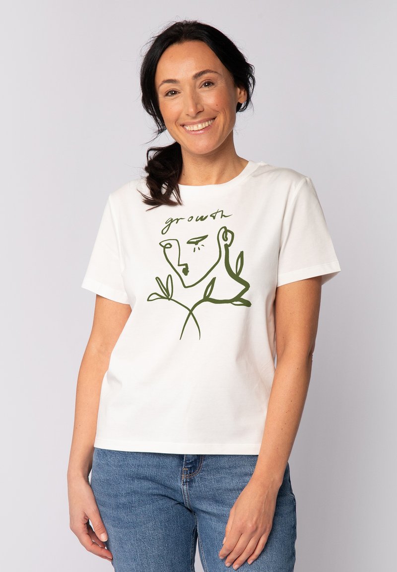 Weißes Baumwoll-T-Shirt mit einer grünen Linzeichnung von einem Gesicht und Pflanzenelementen, mit dem Text "Wachstum" darüber. Kurze Ärmel und lockere Passform.