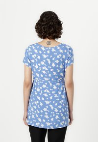 Tunic floreale blu con maniche corte, vita arricciata e orlo svasato. Pattern di fiori bianchi su tutto il tessuto. Texture in tessuto morbido.