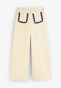 Wide-leg yellow pants with a textured finish. Features contrasting navy rickrack trim on the pocket edges and side seams.