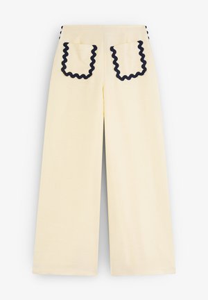 Weite gelbe Hosen mit strukturiertem Finish. Mit kontrastierenden marineblauen Rüschendetails an den Taschenrändern und Seitennähten.