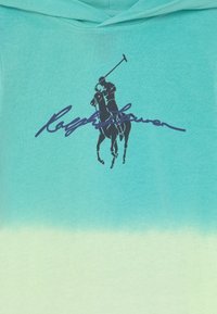 Sudadera con capucha en un degradado de color teal a verde claro. Presenta el logo de polo en color marino y el texto "Ralph Lauren" en cursiva. Tejido de mezcla de algodón.