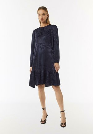 Navy blue dress with long sleeves, a tiered hem, and a subtle zebra pattern. Smooth fabric with a relaxed fit and round neckline.