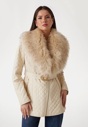 Gequilted crèmekleurige jas met een grote beige nepbontkraag, een ceintuur en accenten van goudkleurige hardware. Standaard pasvorm met ritszakken.
