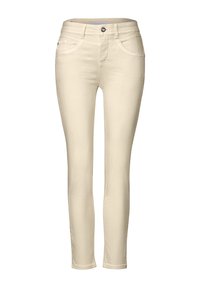 Jeans skinny beige hechos de tejido elástico, con un diseño clásico de cinco bolsillos, cierre de cremallera con botón y sutiles detalles de costura.