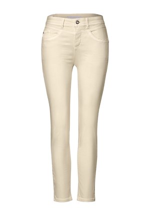 Jeans skinny beige hechos de tejido elástico, con un diseño clásico de cinco bolsillos, cierre de cremallera con botón y sutiles detalles de costura.