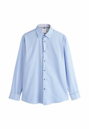Ljusblå långärmad skjorta gjord av ett mjukt tyg. Har en spetskrage, knappar framtill och ett subtilt mönstrat inre foder.