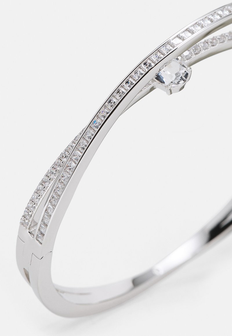 Bracciale in argento con due bande curve, decorato con pietre chiare e simili a diamanti, che mette in risalto una pietra centrale trasparente. Finitura liscia e lucida.