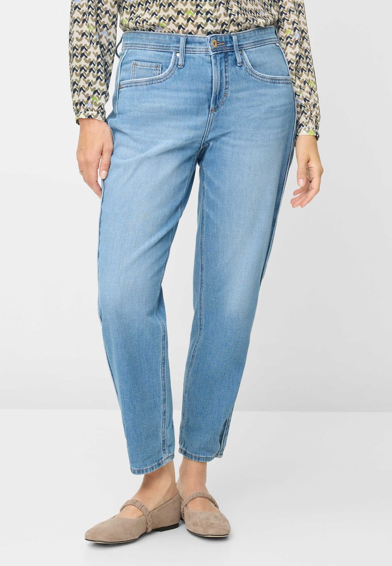 Lyseblå denimjeans med løs pasform, der har forlommer, diskrete syningsdetaljer og en let tilspidset benform.