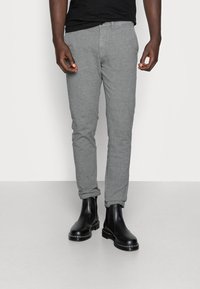 Grå texturerade byxor med slim fit, med uppvikta nederkanter och sidofickor, i kombination med svarta ankelboots.