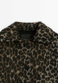 Manteau à col avec motif léopard marron et noir, doté de deux boutons noirs visibles et d'un tissu doux et texturé.