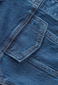 Denim fabric with a textured surface, featuring a slant pocket design. The color is deep blue with contrasting yellow stitching along edges.