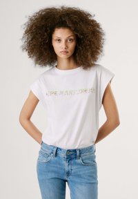 Valge puuvillane T-särk koos rullitud varrukatega, millel on "PEPE JEANS LONDON" värvilises, gradienttekstis. Sobitatud helesiniste denim pükstega.