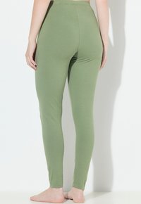 Zielone legginsy bawe�łniane o gładkiej teksturze i dopasowanym kroju, z wysokim stanem i długością do kostek.
