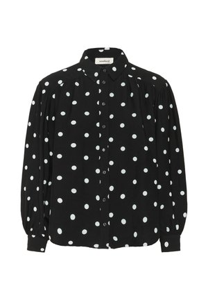 Camisa negra de botones con lunares blancos, de mangas largas y con un cuello estructurado. Presenta detalles plisados en los hombros para añadir textura.