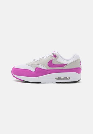 Biały i różowy sneaker Nike Air Max z widoczną podeszwą powietrzną, różowym logo Swoosh oraz zamszowymi nakładkami na prostym białym tle.