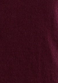 Tissu texturé bordeaux avec un tissage fin, présentant une finition douce et mate ainsi qu'une couleur uniforme. Aucun motif ou accent visible.