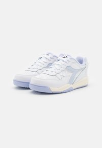 White and light blue athletic shoes with perforated leather upper, padded collar, and rubber sole. Features a distinctive side logo and textured accents.