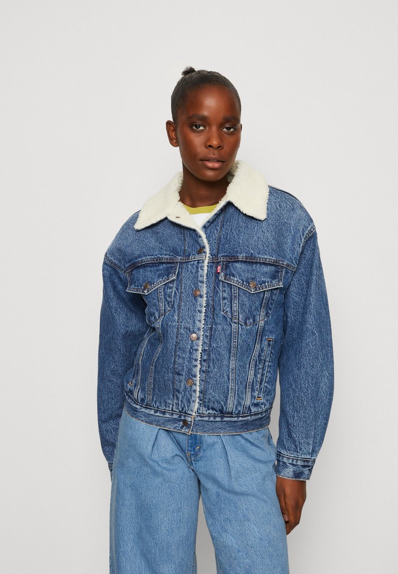 Jeansjack met een lichtblauwe wassing, nep-shearling kraag, schuine zakken aan de voorkant en knoopsluiting. Heeft een relaxed fit en zichtbare stikseldetails.