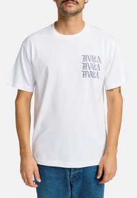 Witte katoenen T-shirt met korte mouwen, voorzien van een verticale blauwe logo-afdruk op de linkerborst. Klassieke ronde halslijn, ontspannen pasvorm.