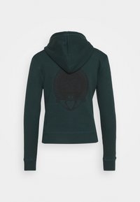 Mörkgrön huvtröja med långa ärmar och en subtil cirkulär logotyp centrerad på ryggen.